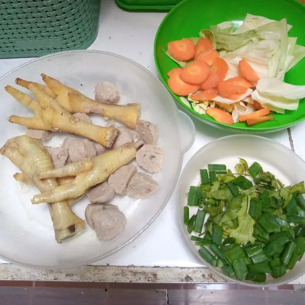Rebus terlebih dahulu ceker ayam hingga empuk. Potong-potong bakso, wortel dan kubis. Iris-iris daun bawang dan seledri