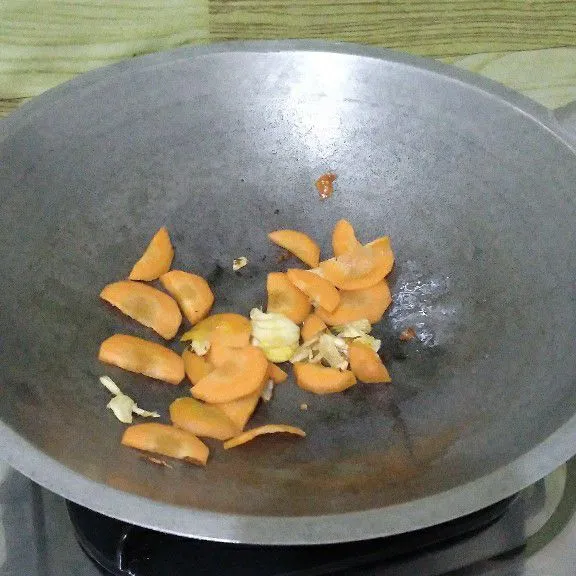 Tumis bawang putih sampai harum. Masukkan wortel dan air masak sampai wortel setengah empuk.