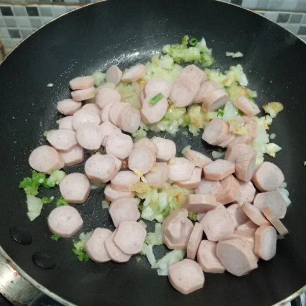 Masukkan sledri dan sosis. Masak hingga sosis berubah warna