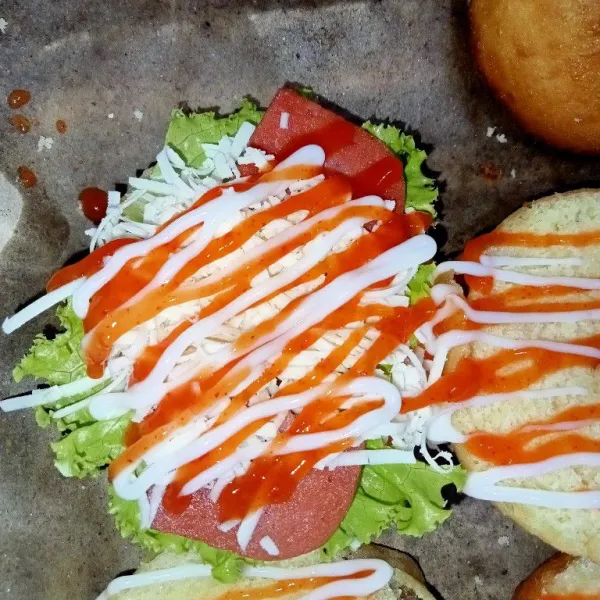 Letakkan selada diatas donat, tambahkan beef luncheon keju dan saus tomat/sambal, dan mayonaise, kemudian tutup, tambahkan hiasan mata sajikan