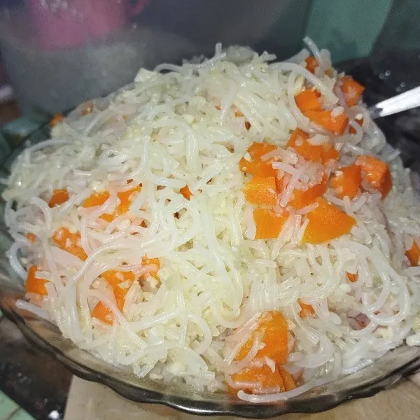 Campur bihun, wortel, dan bumbu sambil dipanaskan. Aduk sampai rata.