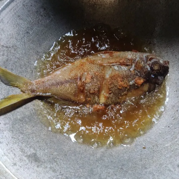 Goreng ikan di minyak panas hingga matang.