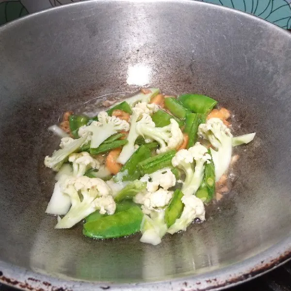 Kemudian tuang secara air. Masukkan sayuran. Aduk rata.