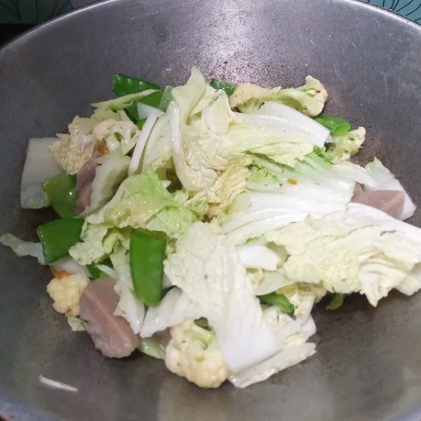 Masukkan bakso. Juga kaldu bubuk, merica bubuk. Aduk rata.
