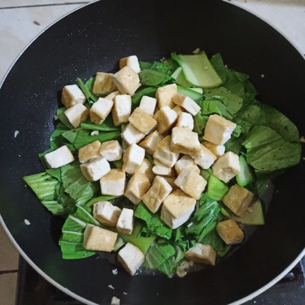 Masukkan tahu yang sudah digoreng bentar dan masukkan pakcoy, aduk rata