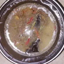 Tuang air, tumisan bawang, seasoning, serta teri goreng ke dalam beras yang telah dicuci.