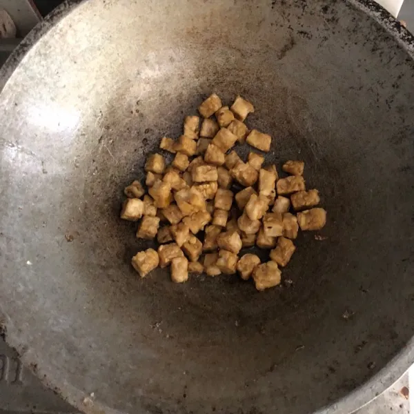 Potong tempe berbentuk dadu. Goreng tempe hingga berwarna kuning kecoklatan.