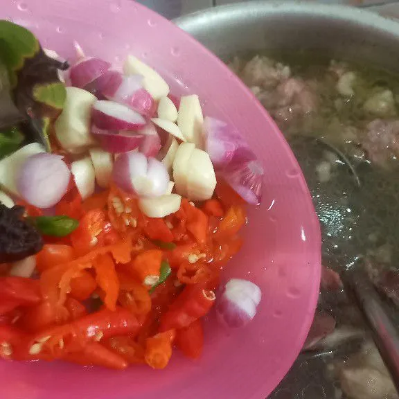 Masukkan potongan cabe, bawang merah, bawang putih, daun salam, lengkuas dan asam jawa.