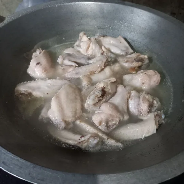 Potong-potong sayap ayam kemudian rebus sebentar dan buang airnya.