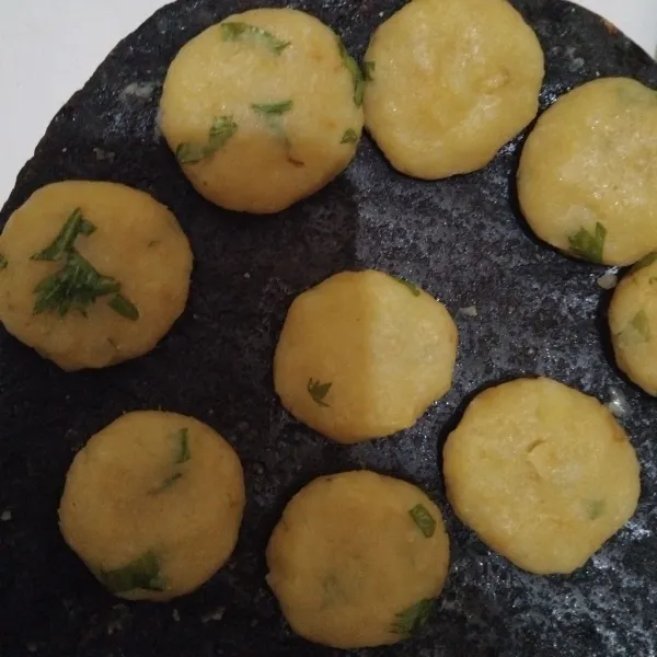Tambahkan daun bawang, aduk rata. Kemudian bulatkan dan pipihkan kentangnya.