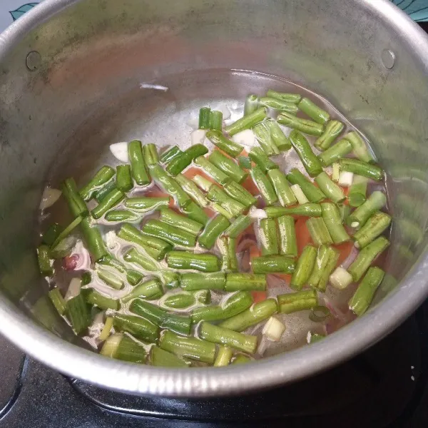 Masukkan buncis dan wortel. Masak sampai sayuran setengah matang.