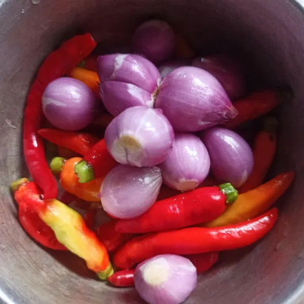 Kupas bawang merah dan buang tangkai cabai rawit kemudian cuci sampai bersih.