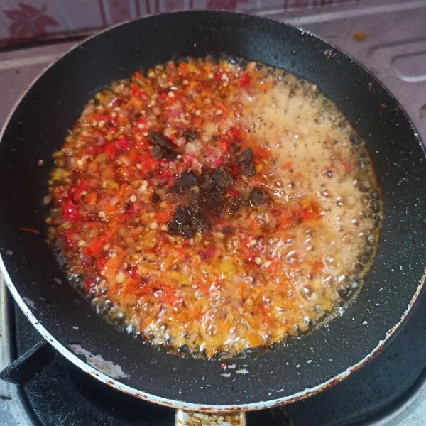 Panaskan minyak goreng, masukkan bawang putih goreng dengan api kecil hingga kecokelatan. Setelah itu sisihkan bawang putihnya kemudian masukkan sambal yang sudah di cooper, masukkan terasi, garam dan gula pasir aduk rata.
