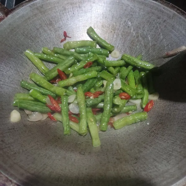 Masukkan kacang panjang, tumis hingga kacang panjang layu.