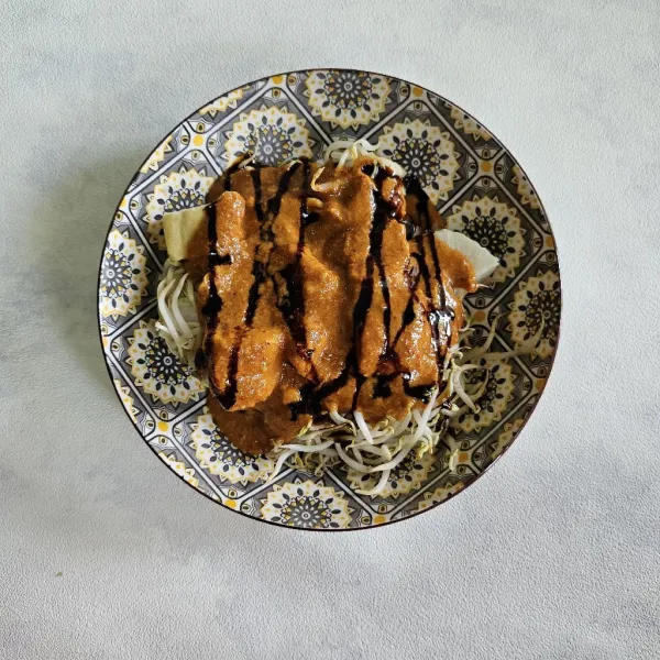 Beri kecap manis dan kerupuk merah serta taburi dengan bawang goreng, lalu sajikan.