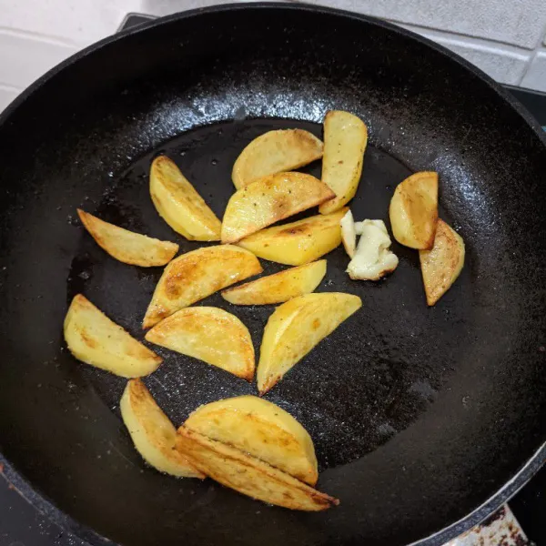 Goreng kentang tanpa minyak. Gunakan sisa menggoreng/sear ayam tadi. Masak hingga matang ya atau berkulit dan empuk di dalam.