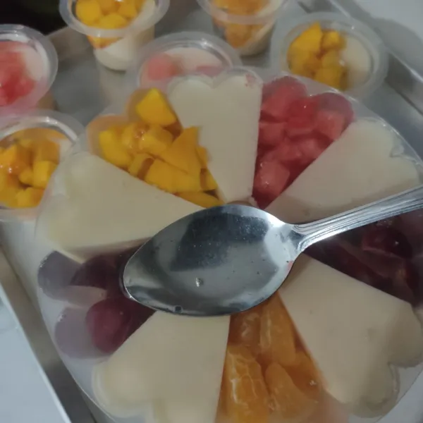 Tuang puding bening kedalam cetakan siramkan kan ke puding buah hingga penuh dan bagian puding susu tertutup puding bening hingga merata. Diamkan hingga set atau dingin kemudian masukan kulkas