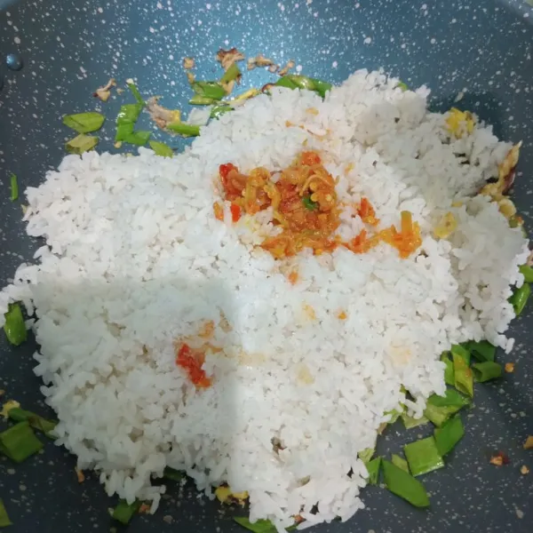 Masukkan nasi putih, sambal, garam, penyedap rasa, aduk-aduk dan tambahkan kecap manis, aduk lagi.