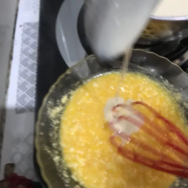 Tuang sekitar 2 centong adonan puding tempe perlahan ke adonan telur, aduk rata, lalu tuang adonan telur ke  dalam adonan tempe.  Masak kembali hingga meletup-letup sambil diaduk. Lalu matikan kompor