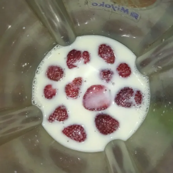 Blender strawberry dengan susu cair.