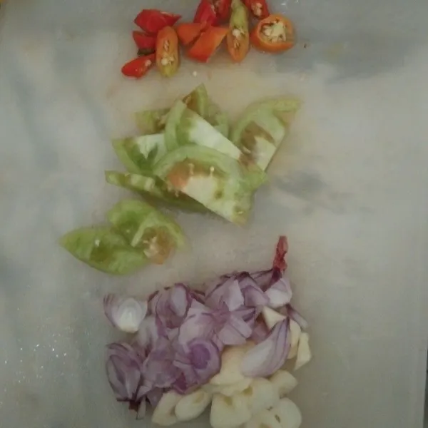 Siapkan irisan bawang merah, bawang putih, cabai rawit dan tomat