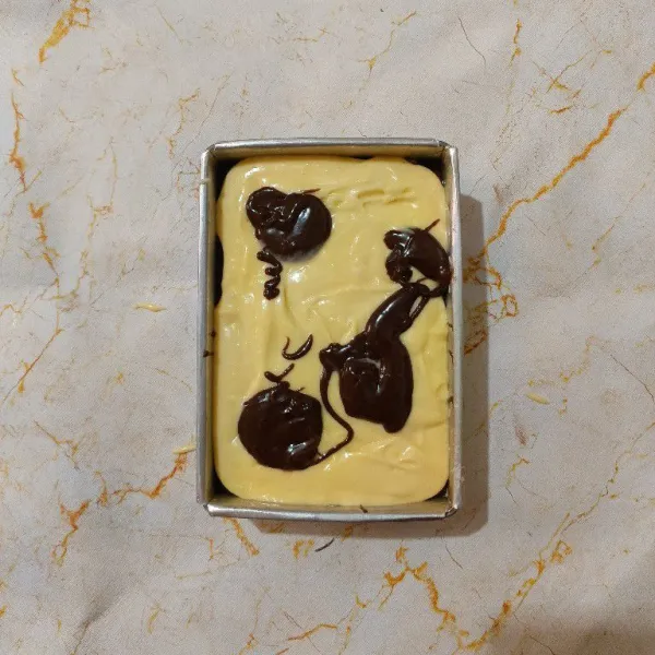 Masukkan adonan cream cheese diatas adonan brownies, kemudian tambahkan sisa adonan coklat.