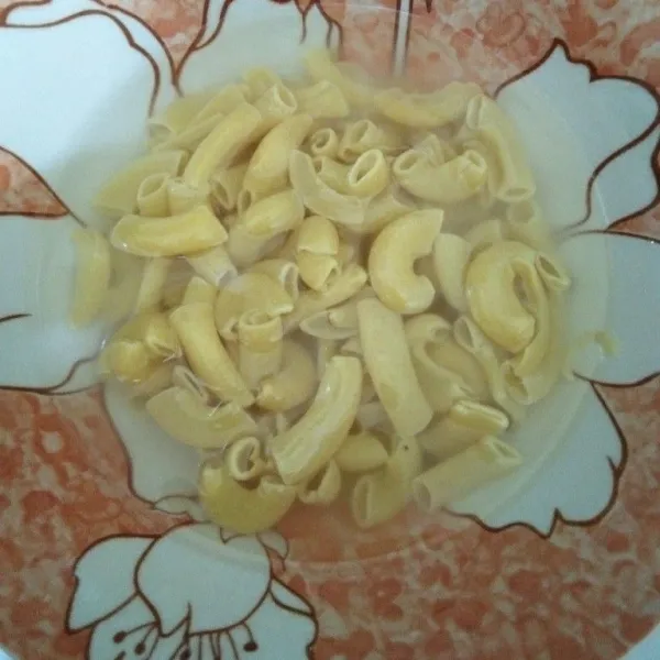 Rendam makaroni dengan air hangat hingga lunak, lalu bilas sampai air berwarna bening