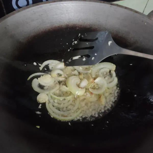 Tumis bawang bombay dan bawang putih hingga harum