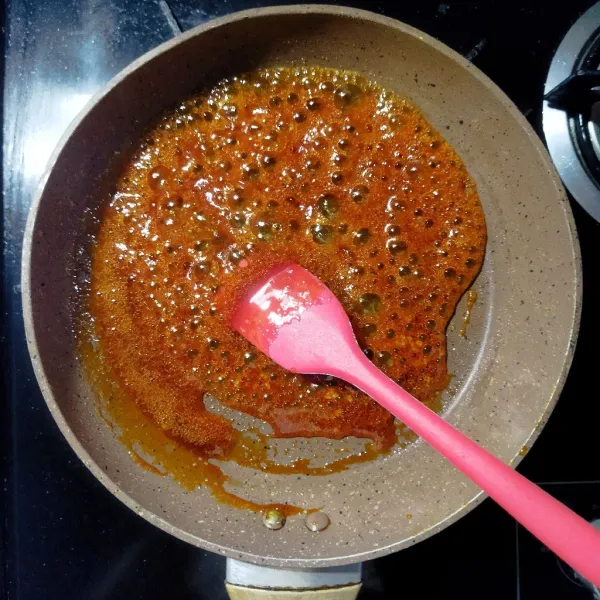 Siapkan teflon lalu taburkan gula pasir di atasnya lalu masak dengan api kecil hingga cair dan berwarna coklat, jangan diaduk. Lalu hati-hati tuang air di atasnya hingga karamel mencair dan kental.