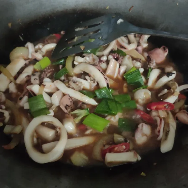 Tambah sedikit air aduk rata, masukan potongan daun bawang aduk rata. Masak cumi hingga bumbu meresap dan cumi kaku mengeras, koreksi rasa, matikan kompor