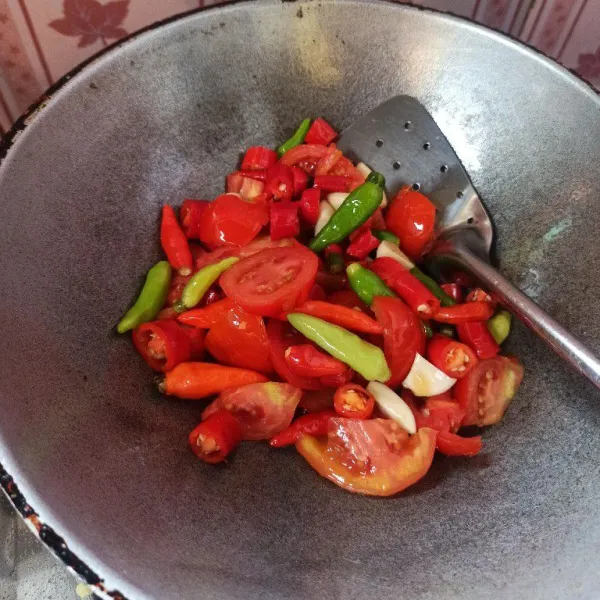 Selanjutnya goreng bawang putih, cabai dan tomat sampai matang.