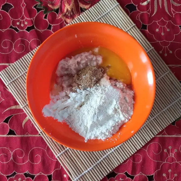 Siapkan mangkuk, lalu letakkan daging ayam yang telah diblender halus, tambahkan satu butir telur, tepung terigu, tepung maizena dan kaldu bubuk rasa sapi.