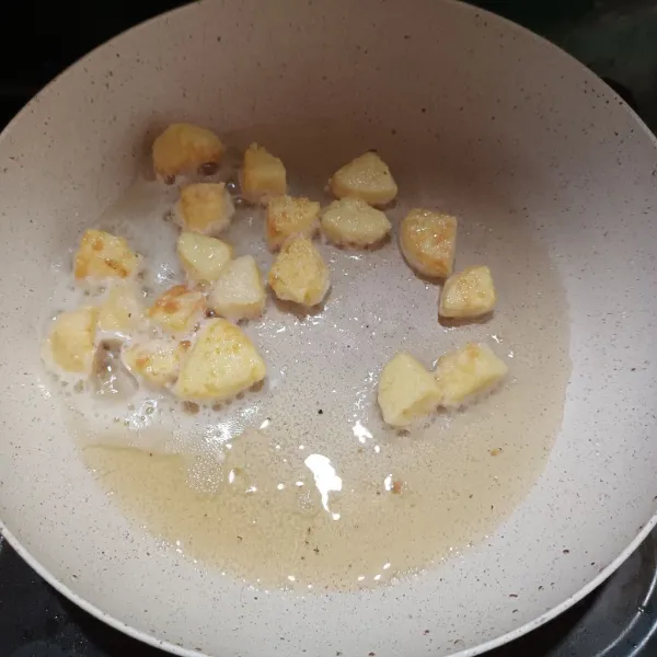 Potong dadu tofu, lalu lumuri dengan tepung maizena. Goreng sampai agak kecoklatan. Angkat dan tiriskan.