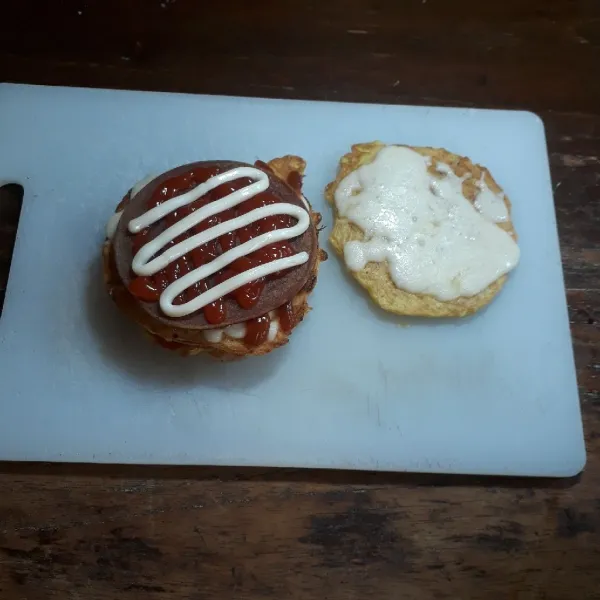 Susun dan tata pancake, daging burger, saus lombok, saus tomat dan mayonaise. Terakhir tumpuk dengan pancake, sajikan.