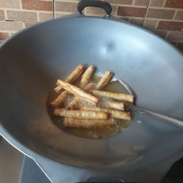 Goreng pangsit gulung dengan minyak panas hingga matang kecokelatan, angkat dan tiriskan.