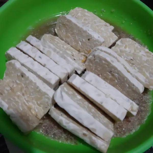 Kemudian tuang bumbu halus ke wadah. Iris tempe lalu balurkan ke bumbu halus