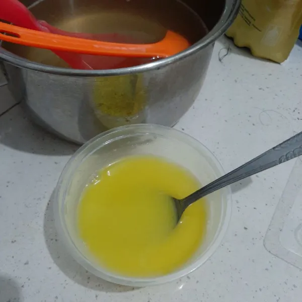 Ambil 5 centong puding cair. Beri tambahan kental manis dan pewarna kuning. Aduk rata.
