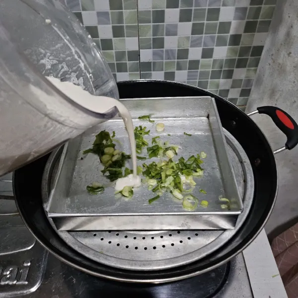 Oles loyang dengan minyak goreng. Taburi dengan sedikit daun bawang. Lalu siram dengan adonan pempek.