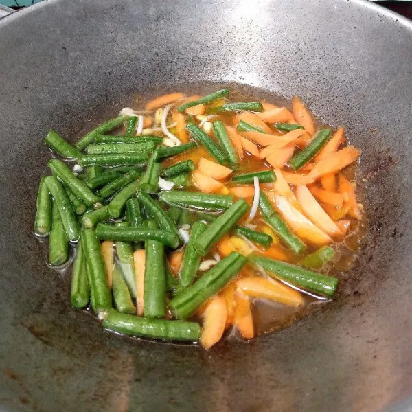 Tuang secukupnya air. Masukkan kacang panjang dan wortel. Aduk rata. Masak hingga kacang panjang empuk.