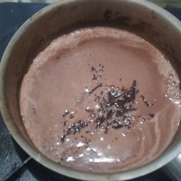 Setelah adonan puding mulai mendidih. Masukan dark cooking chocolate aduk-aduk sampai cokelat larut. Masak puding sampai mendidih lalu angkat.