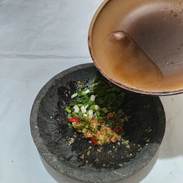 Panaskan minyak goreng, benar-benar panas ya.  Tuang ke atas bumbu yang telah dihaluskan, tambahkan daun bawang, aduk rata.