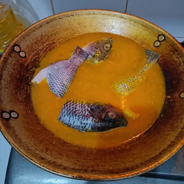 Masukkan ikan, masak hingga ikan matang. Cukup balik sekali saja