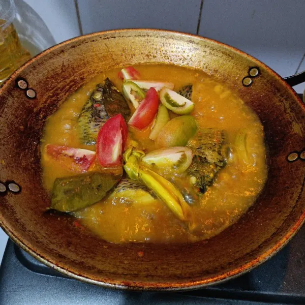 Setelah ikan matang, masukkan potongan tomat. Masak hingga tomat layu dan mendidih. Matikan api dan sajikan