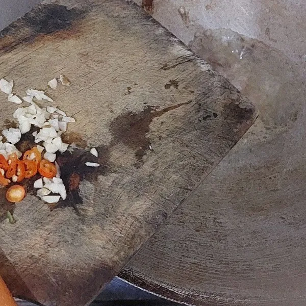 Setelah bawang merah setengah matang, tambahkan cincangan bawang putih dan cabai.