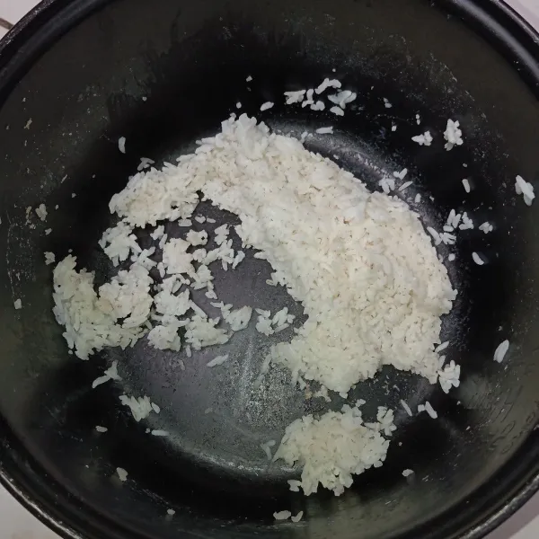 Siapkan nasi dingin, lalu ratakan dengan ulekan agar nasi menyebar.