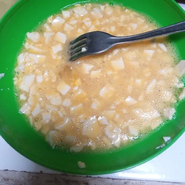 Potong kecil-kecil tahu putih. Campur dengan telur. Tambahkan kaldu bubuk, merica bubuk dan garam. Aduk rata.