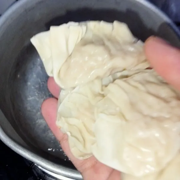 Rebus air hingga mendidih masukkan wonton masak hingga matang