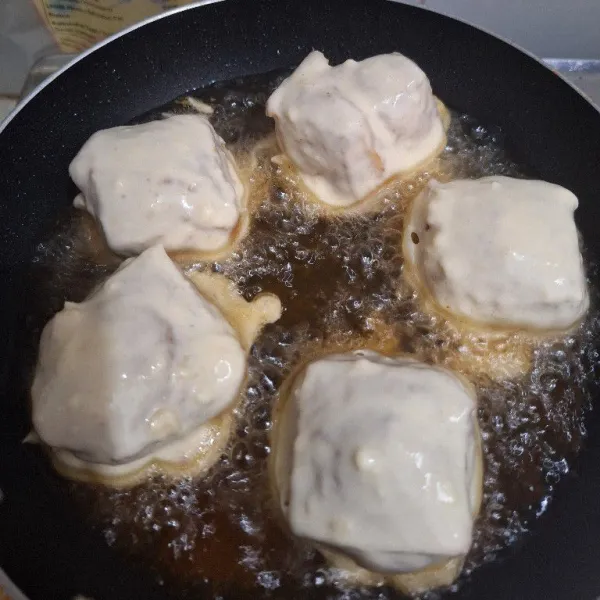 Panaskan minyak. Celupkan tahu ke dalam tepung. Goreng hingga matang.