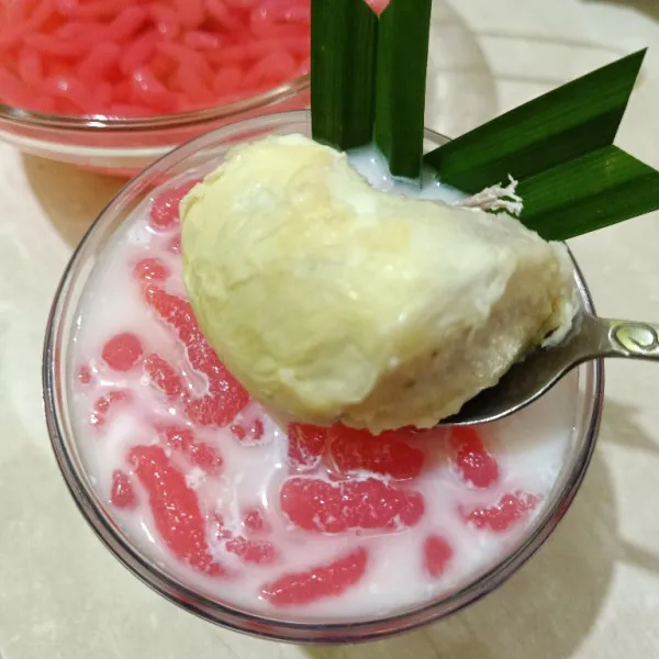 Siapkan gelas saji, ruang es batu secukupnya, kemudian cendol pink, kuah santan, kuah gula merah dan terakhir durian, aduk rata dan sajikan dingin, seger