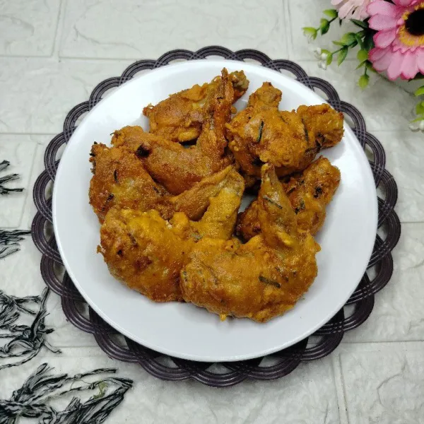 Tata sayap goreng di piring dan sajikan hangat.